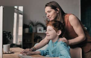 mom helping son on computer
