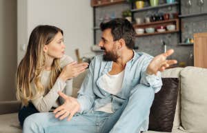 couple arguing while sitting on a couch in the living room
