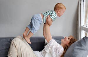 Mom holding a baby up in the air 