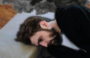 Depressed man laying on couch, zoning out 