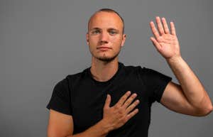 man swearing to tell the truth with hand on heart
