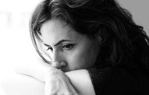 photo of woman looking behind with face on shoulder