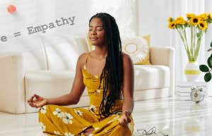 Black woman with long hair meditates on her value in a white living room