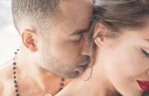 Man kissing womanâs neck 