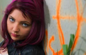 teen girl standing against a wall