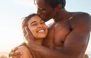 man kissing woman at the beach