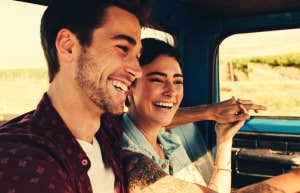 Cheerful young couple on a road trip enjoying the ride