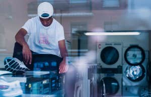 young man sitting in laundromat