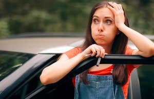 woman looking distraught with car door open