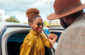 classy woman is helped out of the car by a man