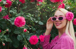 woman next flower bush in sunglasses