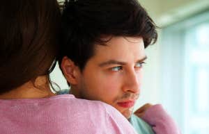 woman hugging unsure boyfriend