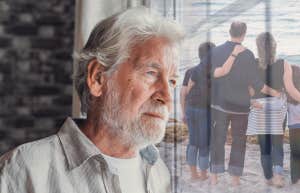 old man looking at the window and faded picture of family