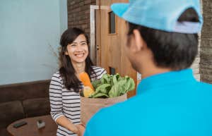 Woman receiving grocery delivery from Uber Eats