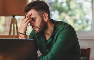 stressed man working at laptop