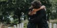 people hugging at cemetery 