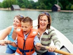 two women with young boy in rowboat