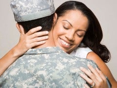 Woman embracing man in fatigues