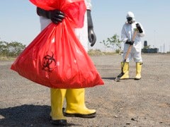 Workers in protective suits disposing of hazardous waste