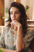 Woman reflecting with sadness, representing how past trauma and limiting beliefs can block self-love and personal healing