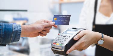 person using credit card to pay for purchase