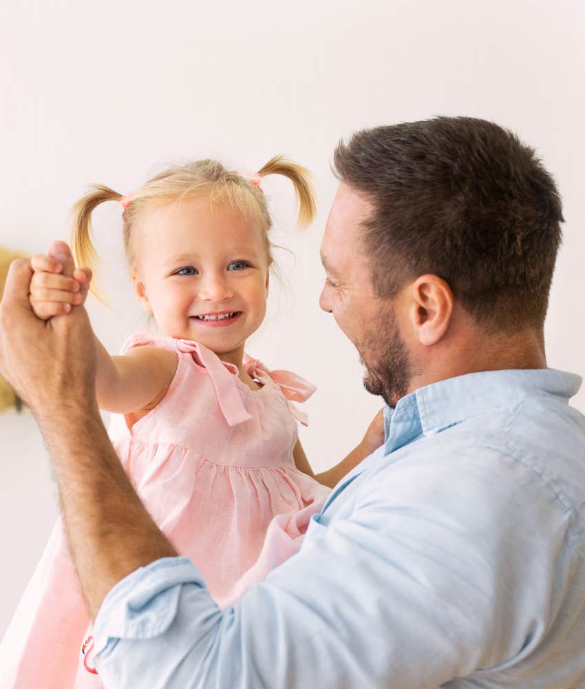 dad and toddler daughter dancing