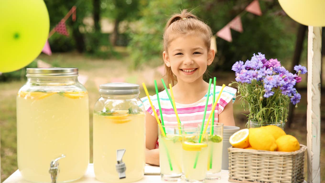 little girl behind lemonade stand